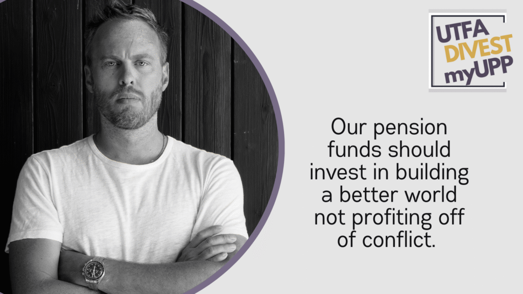 A white man in a white t-shirt with a serious look on his face and a cropped, light coloured beard.